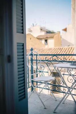 a table and chair sitting on a balcony at Neapolis 1897 Boutique Luxury Rooms in Athens
