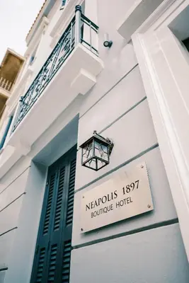 a sign for a hotel on the side of a building at Neapolis 1897 Boutique Luxury Rooms in Athens