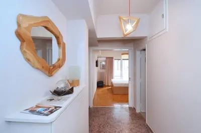 a hallway with white walls and a mirror on a wall at Studio in the heart of Athens, next to Metro &... in Athens