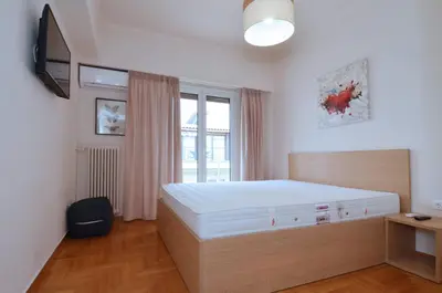 a bedroom with a large bed and a television at Studio in the heart of Athens, next to Metro &... in Athens