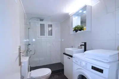 a white bathroom with a toilet and a shower at A spacious minimal apatment at Chalandri in Athens