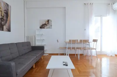 a living room with a couch and a table at A cozy minimal apartment at Koukaki, Dimitrako... in Athens