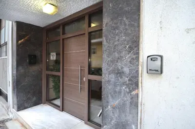 a wooden door on a building with a sign on it at A minimal retire at Kypseli with an amazing view in Athens