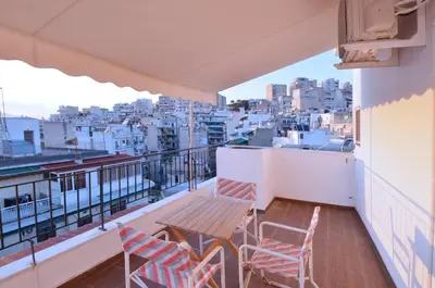 a balcony with a table and chairs and a city at A minimal retire at Kypseli with an amazing view in Athens