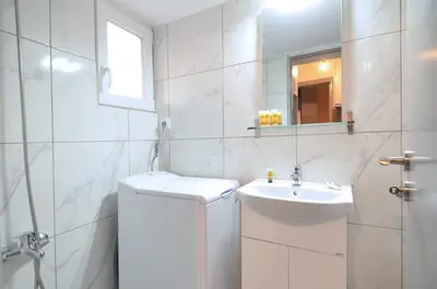 a white bathroom with a sink and a mirror at A minimal retire at Kypseli with an amazing view in Athens