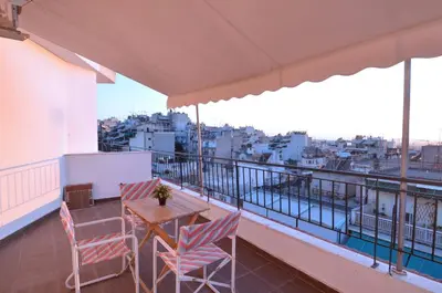 a balcony with a table and chairs and a view at A minimal retire at Kypseli with an amazing view in Athens