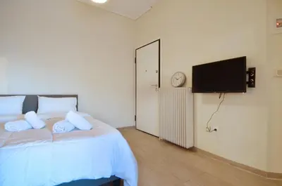a bedroom with a bed and a flat screen tv at A minimal retire at Kypseli with an amazing view in Athens