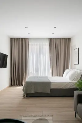 a bedroom with a bed and a large window at The Artisan Suites in Athens