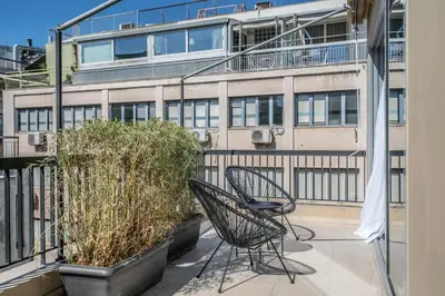 two chairs on a balcony with a building at The Artisan Suites in Athens