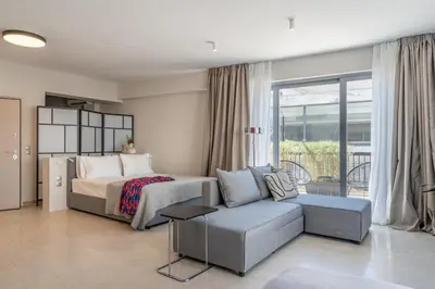 a bedroom with a bed and a couch and a bed and a window at The Artisan Suites in Athens