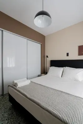 a bedroom with a large bed and a large window at The Artisan Suites in Athens