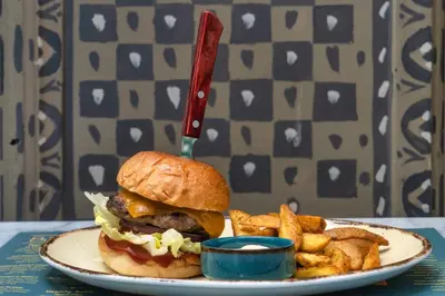 a sandwich and french fries on a plate with a knife at The Artisan Suites in Athens