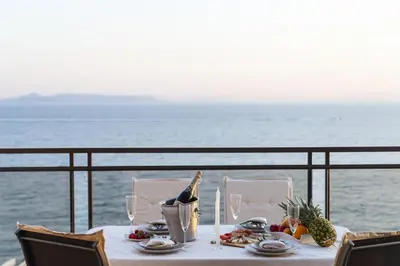 a table with food and wine on a balcony with the ocean at Blue Dreams - Spectacular Sea View Apartment in Athens in Athens