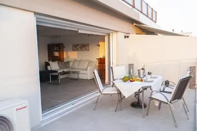 a patio with a table and chairs and a living room at Blue Dreams - Spectacular Sea View Apartment in Athens in Athens