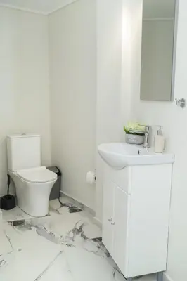 a white bathroom with a sink and a toilet at Blue Dreams - Spectacular Sea View Apartment in Athens in Athens