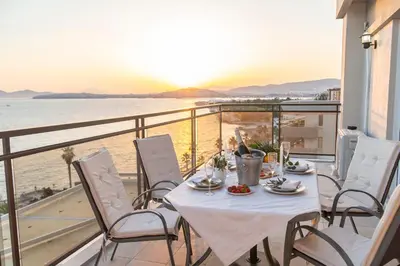 a table and chairs on a balcony with a view of the ocean at Blue Dreams - Spectacular Sea View Apartment in Athens in Athens