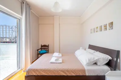a bedroom with a bed with a large window at Koukaki Spacious Penthouse with parking for Small Car in Athens