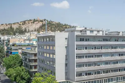 a tall white building in front of a city at Koukaki Spacious Penthouse with parking for Small Car in Athens