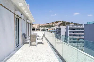 a balcony of a building with chairs on it at Koukaki Spacious Penthouse with parking for Small Car in Athens