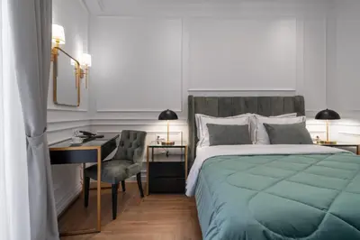 a bedroom with a bed and a desk and a bed sidx sidx sidx at Praxitelous Luxury Suites in Athens