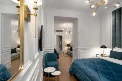 a bedroom with a blue bed and a couch at Praxitelous Luxury Suites in Athens