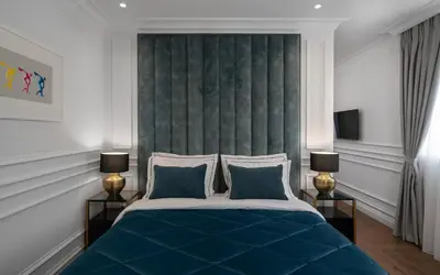 a bedroom with a blue bed with two lamps at Praxitelous Luxury Suites in Athens