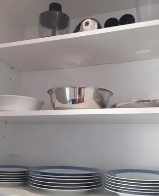 a kitchen shelf with plates and bowls and pans at Athens Anasa's Studio in Athens