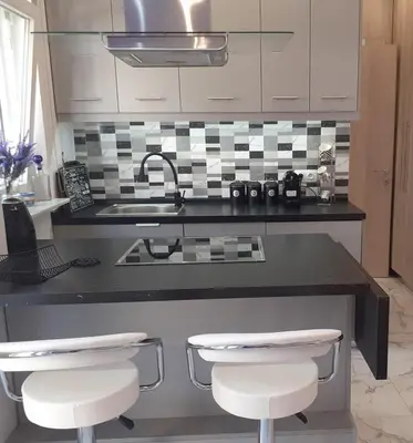 a kitchen with a sink and a counter with two stools at Athens Anasa's Studio in Athens