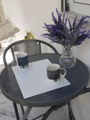 a table with two cups and a vase with purple flowers at Athens Anasa's Studio in Athens