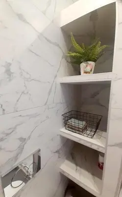 a bathroom with white marble walls and white shelves at Athens Anasa's Studio in Athens