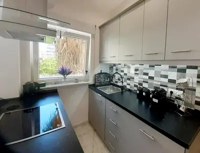 a kitchen with a black counter top and a window at Athens Anasa's Studio in Athens