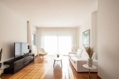 a living room with a white couch and a tv at ATHENS RIVIERA Grand Panoramic Villa Lagonissi in Lagonissi