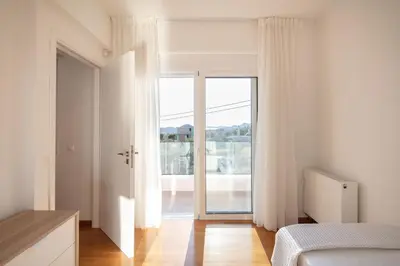 a bedroom with a bed and a large window at ATHENS RIVIERA Grand Panoramic Villa Lagonissi in Lagonissi