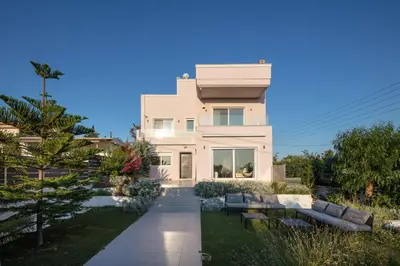 a white house with a garden in front of it at ATHENS RIVIERA Grand Panoramic Villa Lagonissi in Lagonissi