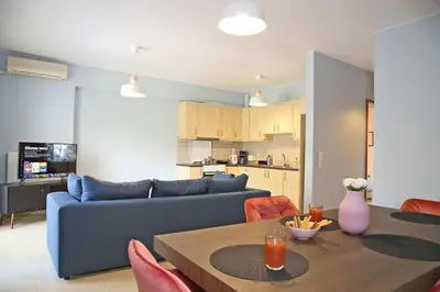 a living room with a blue couch and a table at 2 Bedroom Apartment near the Athens Airport, Spata in Spáta