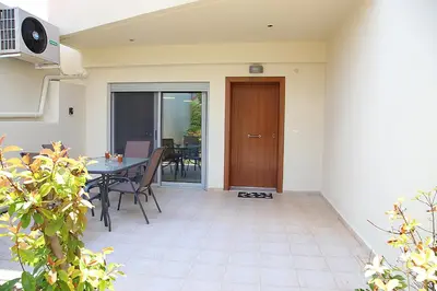 a patio with a table and chairs and a door at 2 Bedroom Apartment near the Athens Airport, Spata in Spáta