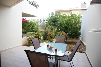 a glass table and chairs on a patio at 2 Bedroom Apartment near the Athens Airport, Spata in Spáta
