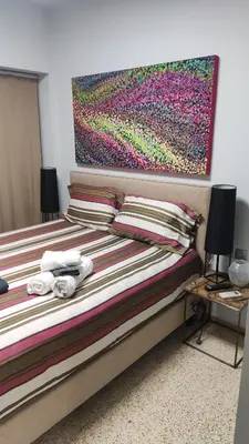 a bedroom with a bed with a painting on the wall at Praxitelous Apartments by Athens Urban Retreat in Athens