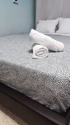 a bed with a white blanket on top of it at Praxitelous Apartments by Athens Urban Retreat in Athens