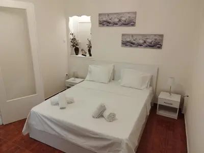 a bedroom with a white bed with two towels on it at Zeus Apartment in Athens