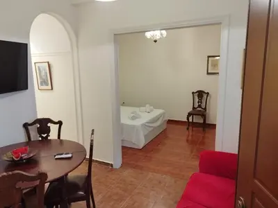 a living room with a table and chairs and a room with a table at Zeus Apartment in Athens