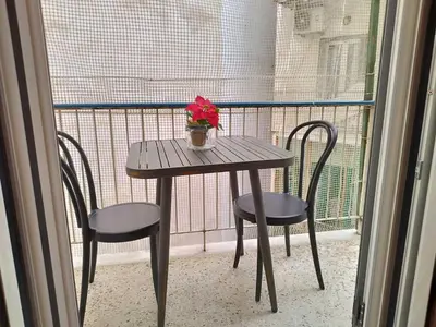 a table with two chairs and a vase of flowers on a balcony at Zeus Apartment in Athens