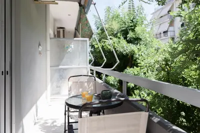 a small table on a balcony with a drink at Heart of Koukaki flat, near Acropolis & Filopappou in Athens