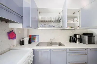 a kitchen with white cabinets and a sink at Heart of Koukaki flat, near Acropolis & Filopappou in Athens