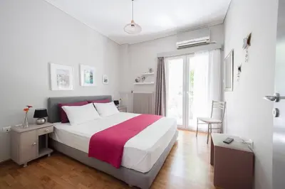 a bedroom with a large bed and a window at Heart of Koukaki flat, near Acropolis & Filopappou in Athens