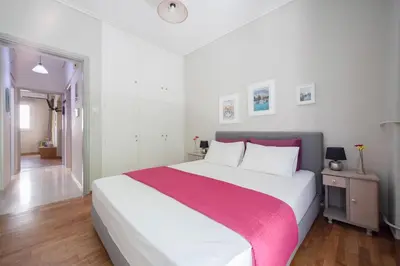 a bedroom with a large bed with a red and white blanket at Heart of Koukaki flat, near Acropolis & Filopappou in Athens