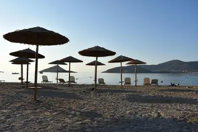 a group of umbrellas and chairs on a beach at Homeyfeel Stay Sea 2 - Island mood studio in Porto Rafti