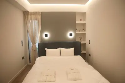 a bedroom with a bed with two towels on it at Athelia Athens in Athens