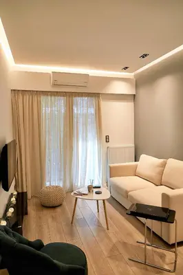 a living room with a white couch and a table at Athelia Athens in Athens