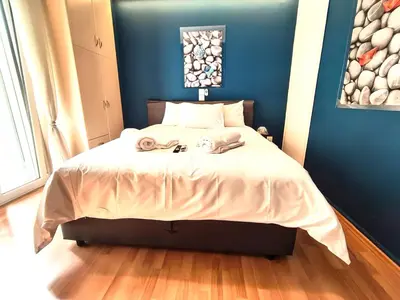 a bedroom with a large bed with a blue wall at Premium GaLeRia 4A in Athens